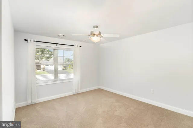 an empty room with fan and entryway