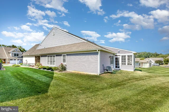 a view of a yard in front of a house with a large tree