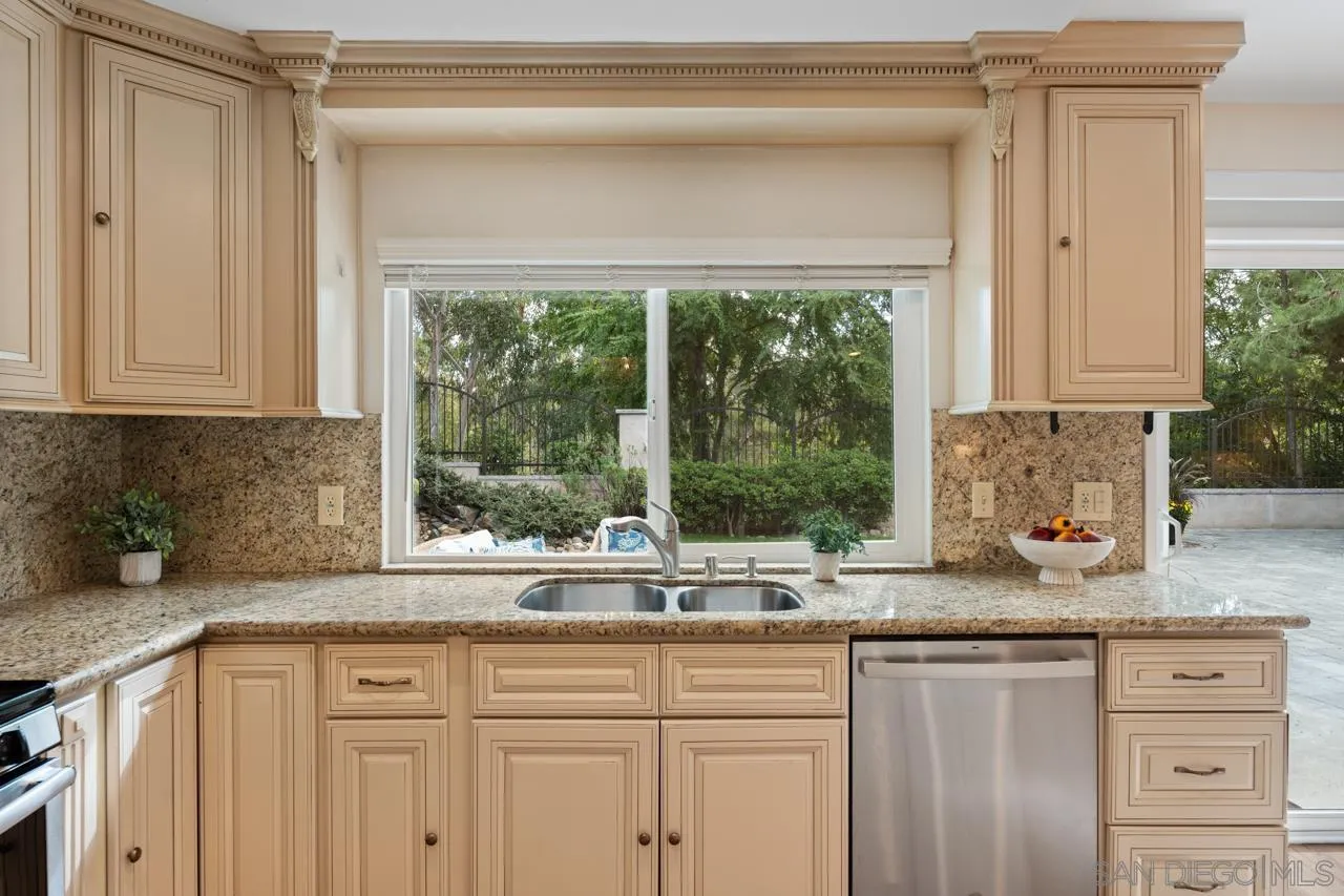 11837 La Colina Road San Diego, CA 92131 - Photo 15 of 35 a kitchen with granite countertop a window sink and cabinets