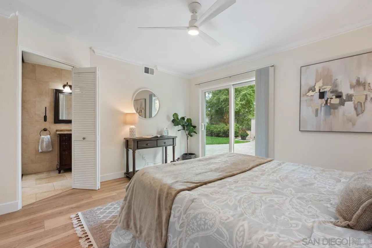 11837 La Colina Road San Diego, CA 92131 - Photo 17 of 35 a bedroom with a large bed and a chandelier