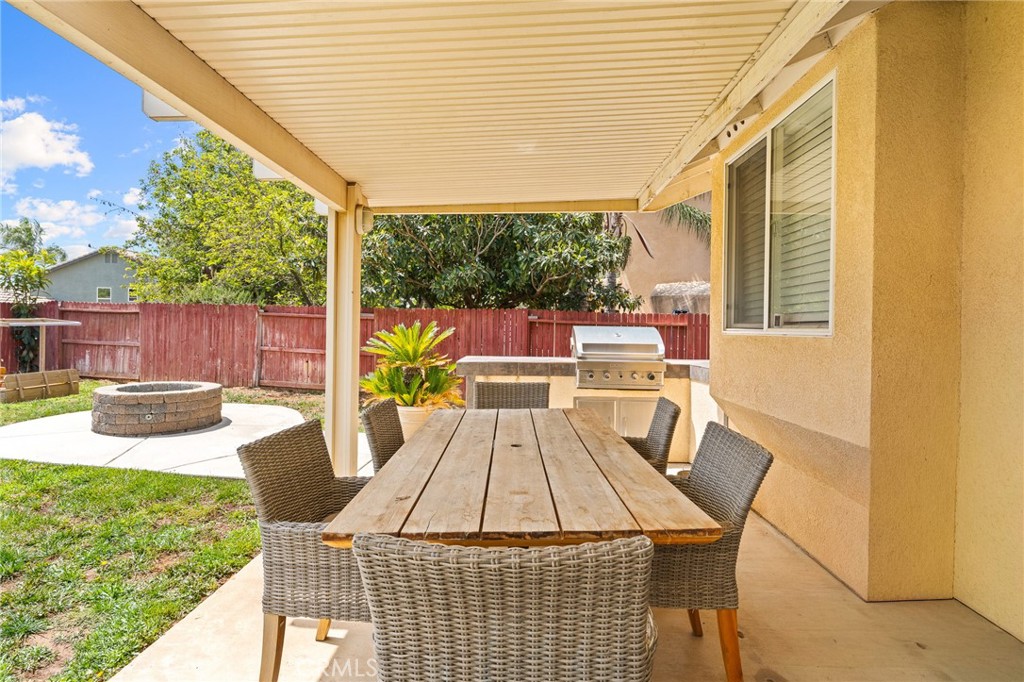 533 Heidi Circle Beaumont, CA 92223 - Photo 24 of 37 a view of a patio with table and chairs potted plants with wooden floor and fence