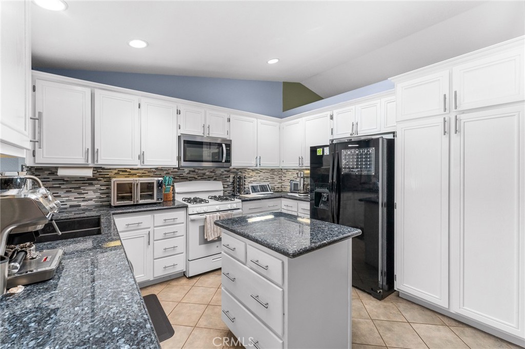533 Heidi Circle Beaumont, CA 92223 - Photo 9 of 37 a kitchen with granite countertop stainless steel appliances a stove refrigerator and microwave