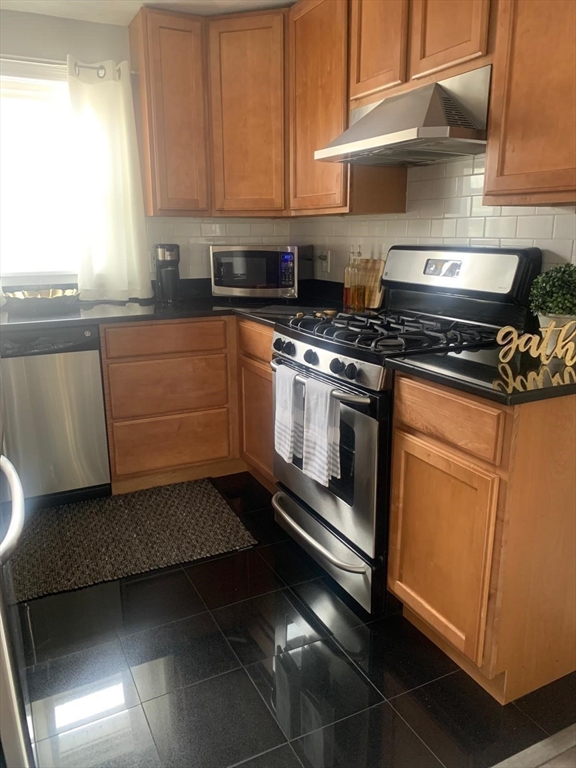 9 Henry Street, Unit 2 Everett, MA 02149 - Photo 7 of 19 a kitchen with granite countertop a stove top oven sink and cabinets