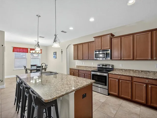 a kitchen with stainless steel appliances granite countertop a stove top oven a refrigerator a sink and dishwasher