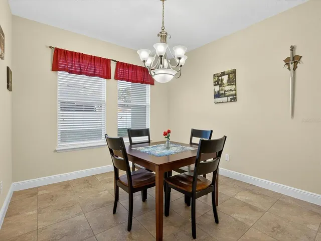 a view of a dining room with furniture a chandelier and wooden floor