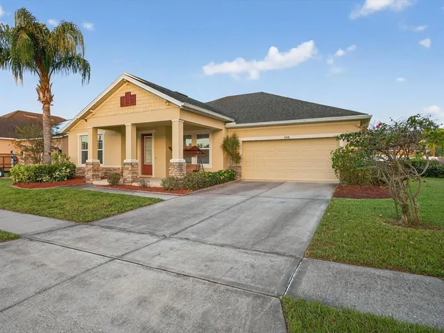 a front view of a house with a yard and palm trees