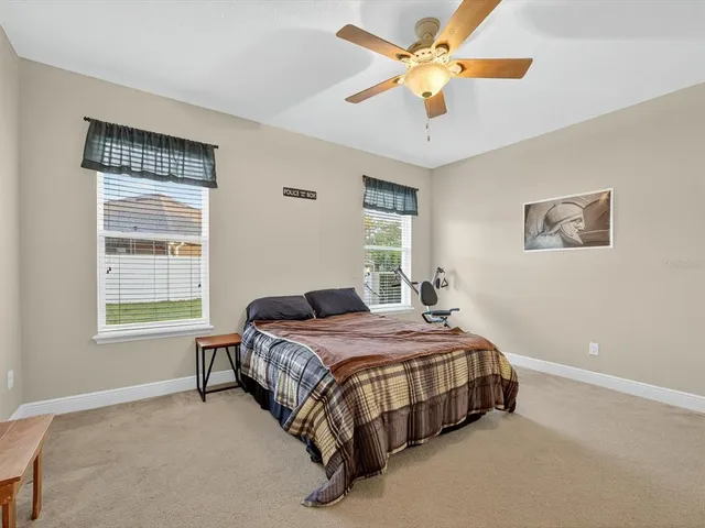 a bedroom with a bed desk and a window