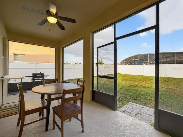 a dining room with furniture and a floor to ceiling window