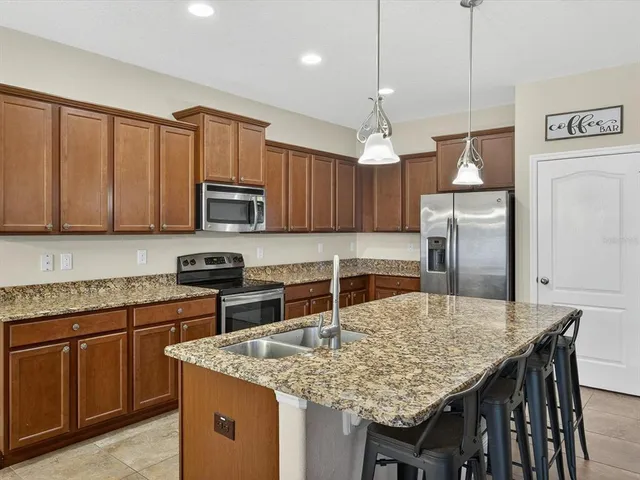 a kitchen with stainless steel appliances granite countertop a kitchen island a cabinets and wooden floor