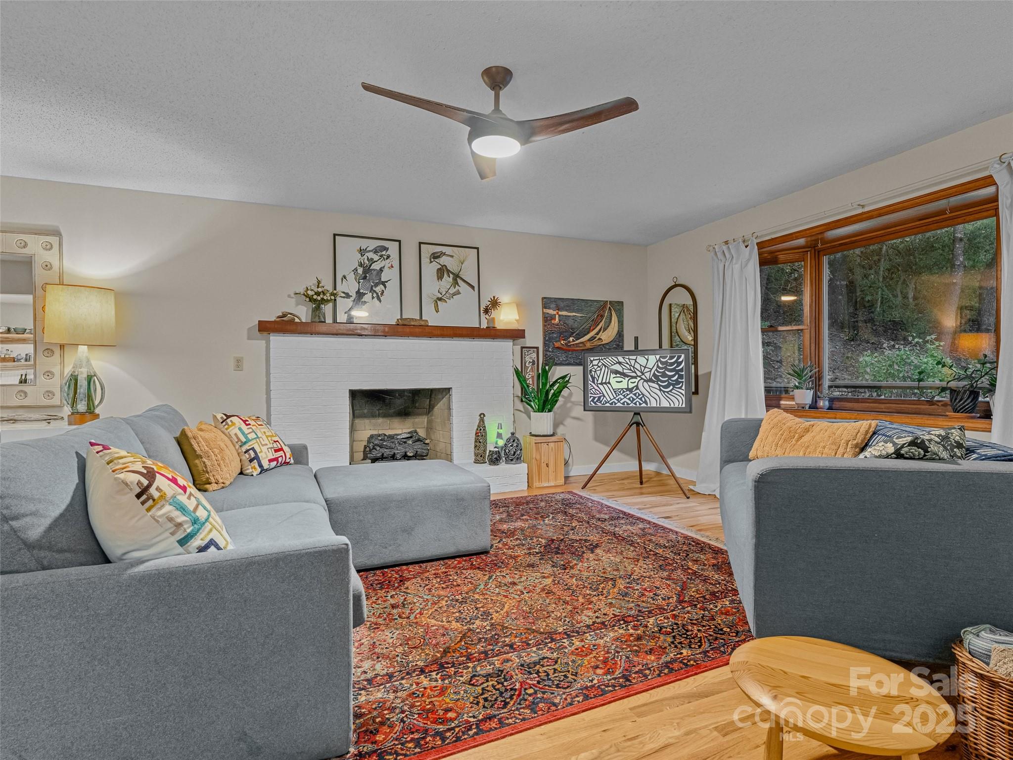197 Tiptop Road Brevard, NC 28712 - Photo 6 of 45 a living room with furniture a fireplace and a floor to ceiling window