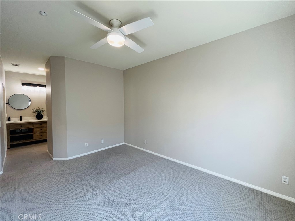 60 Strawflower Street Ladera Ranch, CA 92694 - Photo 14 of 22 an empty room with a mirror and a ceiling fan