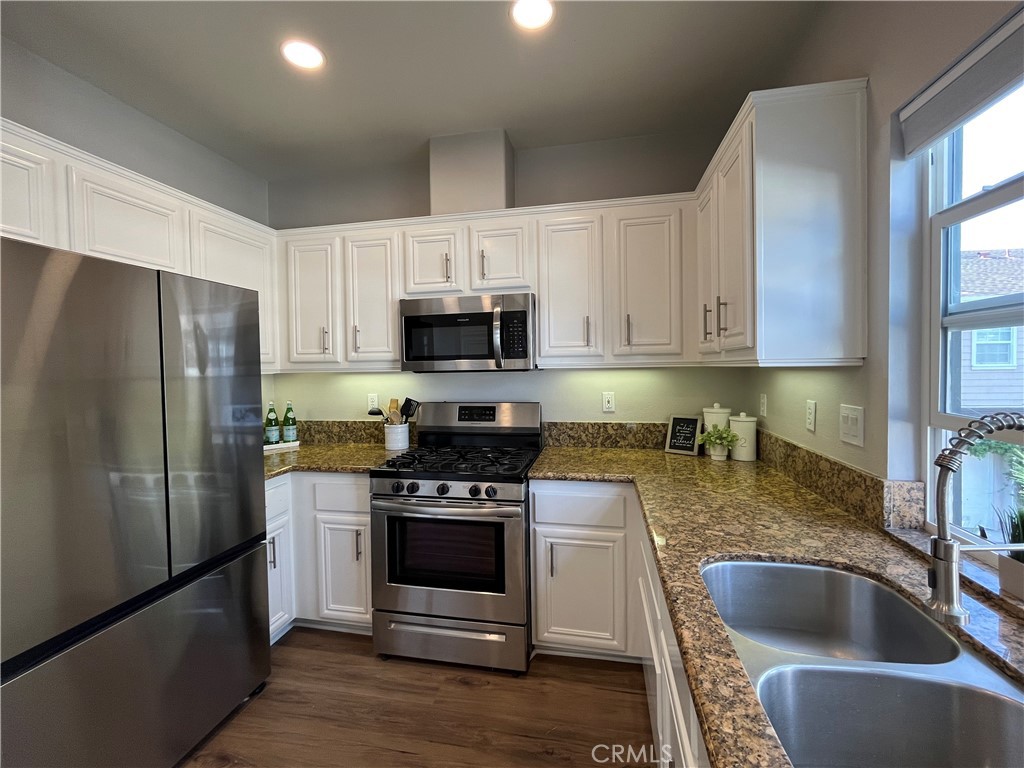 60 Strawflower Street Ladera Ranch, CA 92694 - Photo 8 of 22 a kitchen with kitchen island a white cabinets and stainless steel appliances