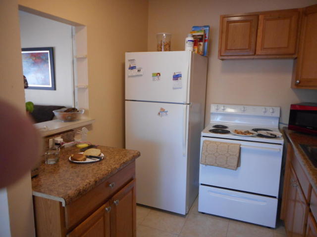 285 Norwich L West Palm Beach, FL 33417 - Photo 2 of 17 a kitchen with a refrigerator and a stove