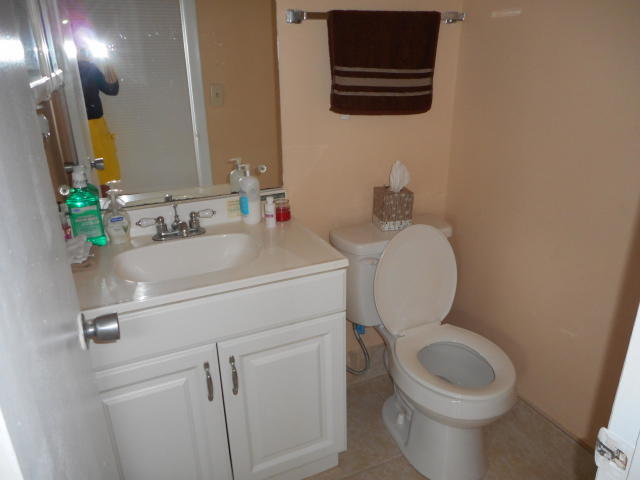285 Norwich L West Palm Beach, FL 33417 - Photo 6 of 17 a bathroom with a toilet sink and mirror