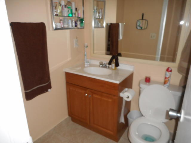 285 Norwich L West Palm Beach, FL 33417 - Photo 7 of 17 a white toilet sitting next to a bathroom sink