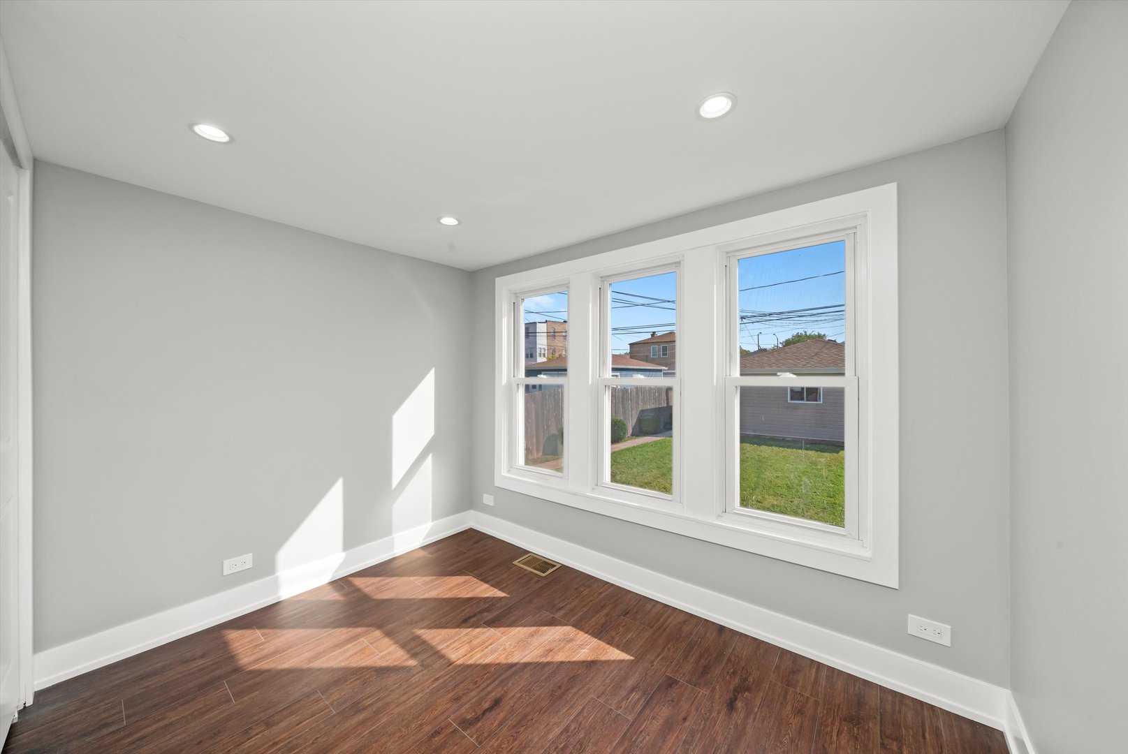 10047 South Calumet Avenue Chicago, IL 60628 - Photo 14 of 32 a view of an empty room with a window and wooden floor