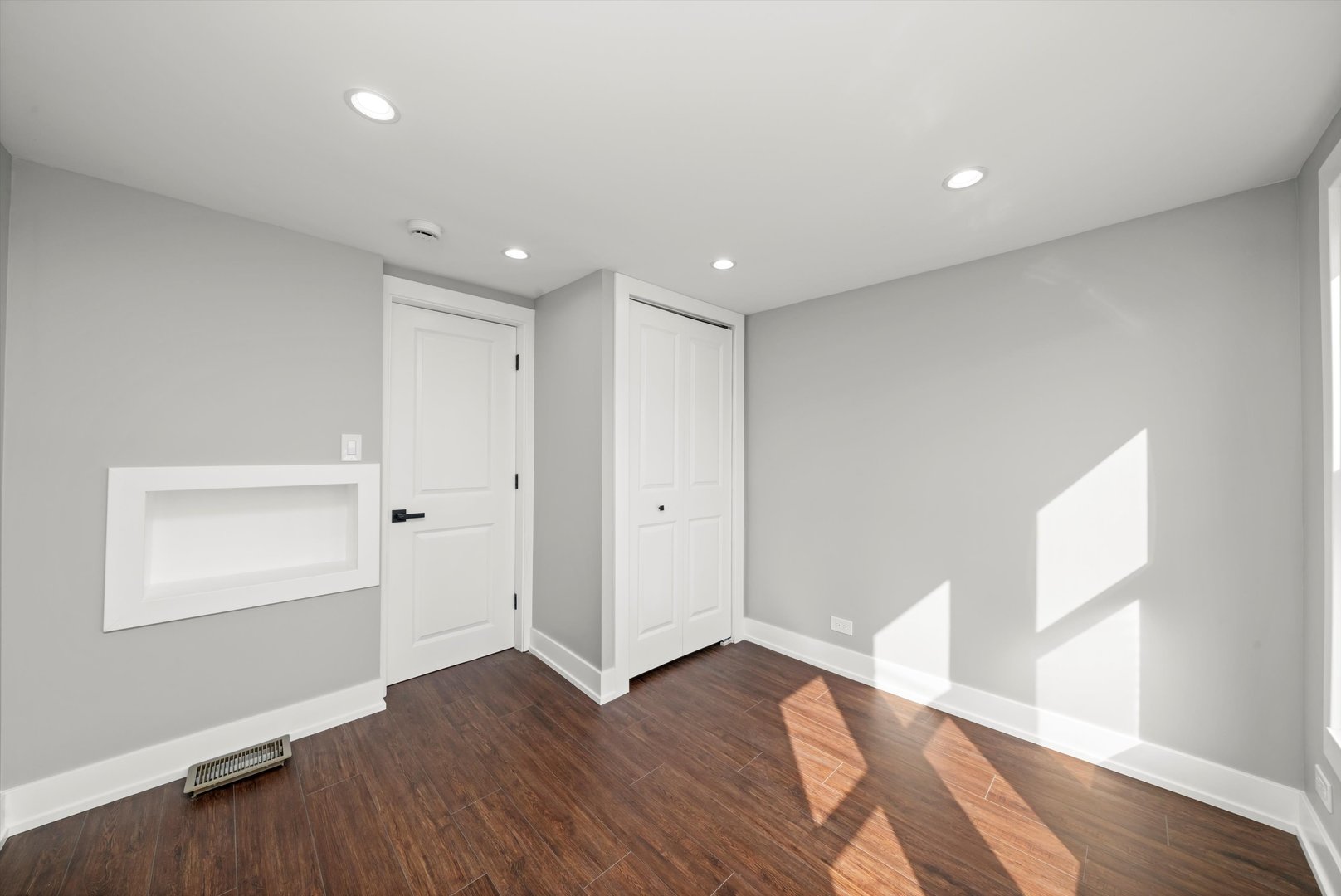 10047 South Calumet Avenue Chicago, IL 60628 - Photo 22 of 32 a view of an empty room with wooden floor and a window