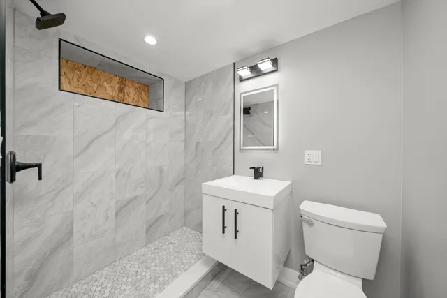 a bathroom with a toilet sink and mirror