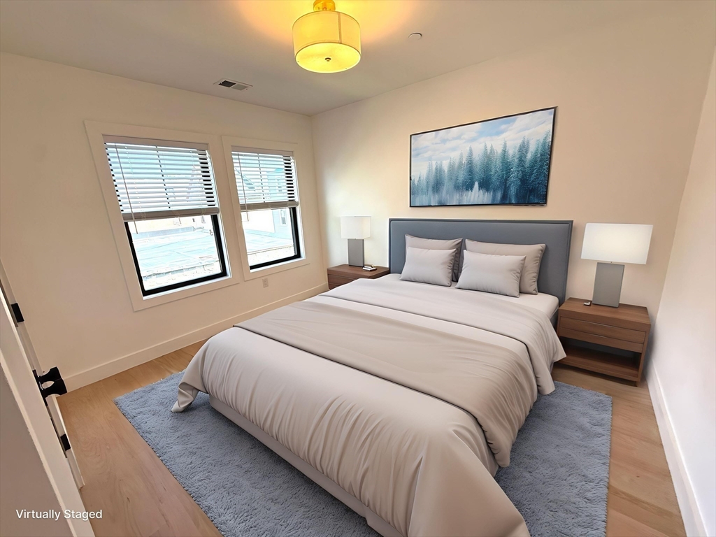 52 Withington Street, Unit 7 Boston, MA 02124 - Photo 11 of 32 a bedroom with a bed and wooden floor
