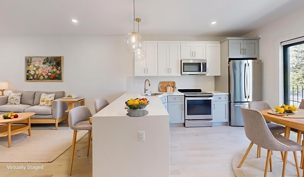 52 Withington Street, Unit 7 Boston, MA 02124 - Photo 3 of 32 a kitchen with stainless steel appliances kitchen island granite countertop a refrigerator and a stove top oven
