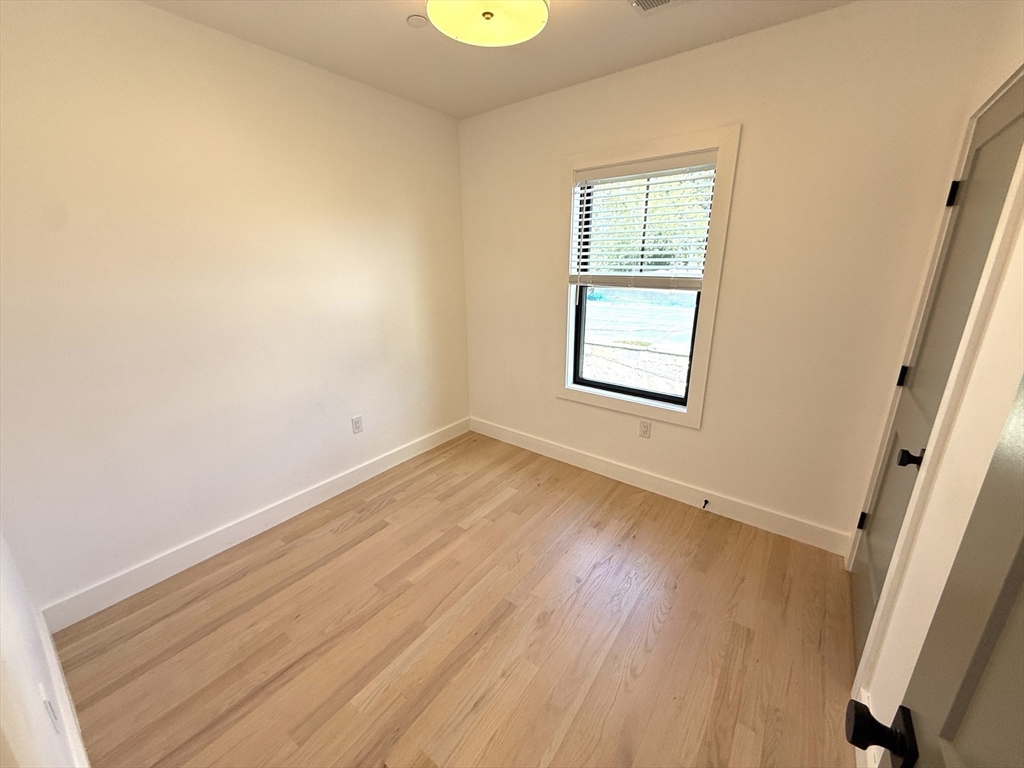 52 Withington Street, Unit 7 Boston, MA 02124 - Photo 10 of 32 an empty room with wooden floor and windows