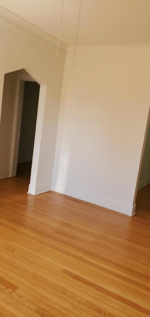 10801 South Indiana Avenue, Unit 2 Chicago, IL 60628 - Photo 8 of 10 a view of an empty room with wooden floor