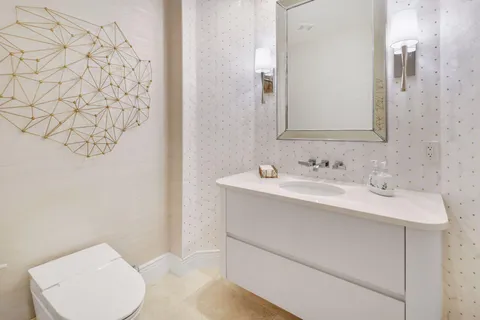 a bedroom with a bed a couch and a flat tv screen on the dresser