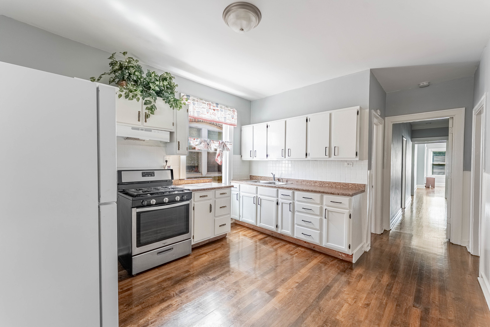 4820 West Wolfram Street, Unit 2 Chicago, IL 60641 - Photo 12 of 18 a large kitchen with cabinets wooden floor and stainless steel appliances