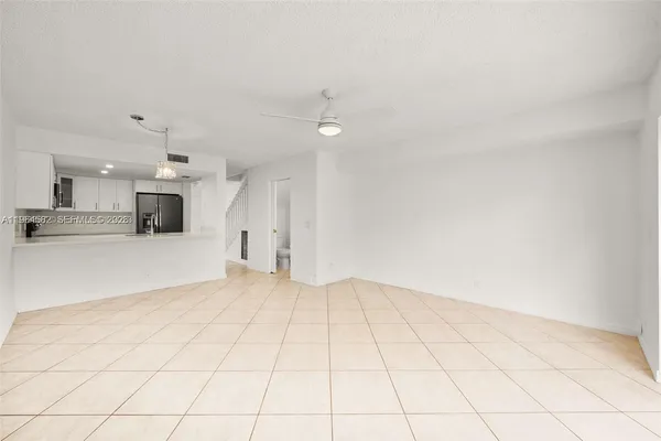 an empty room with kitchen view and a window