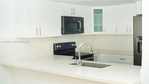 a kitchen with a sink and a stove top oven with wooden floor