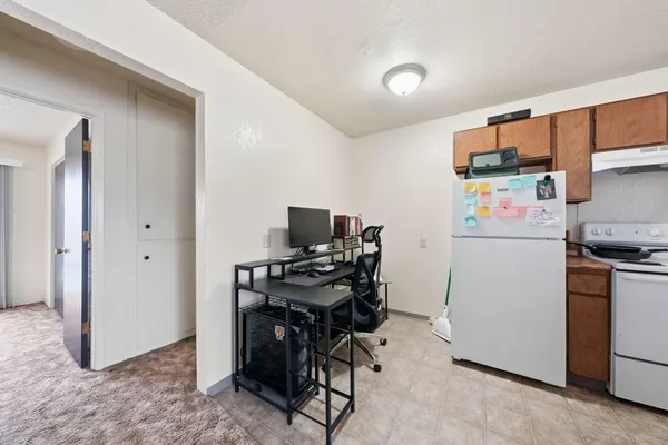 a view of a workspace with furniture and a kitchen