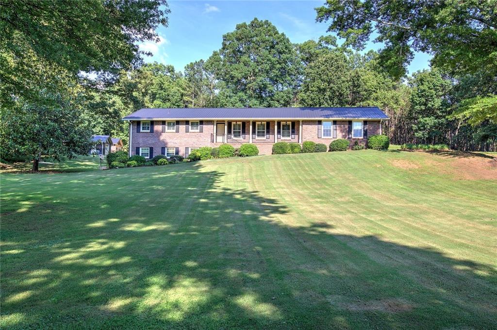 408 Mac Johnson Road Northwest Cartersville, GA 30121 - Photo 78 of 79 a view of a big yard next to a brick house with a big yard