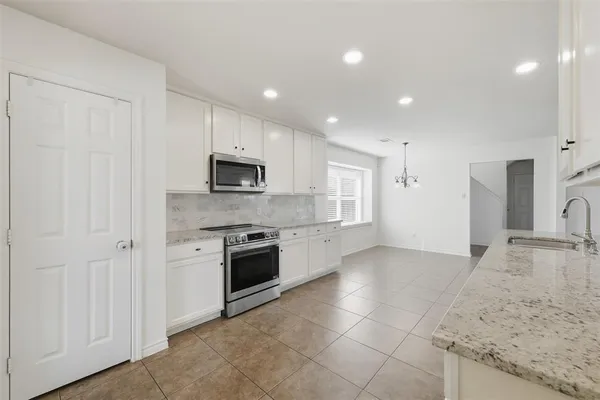 a large kitchen with a stove and a sink