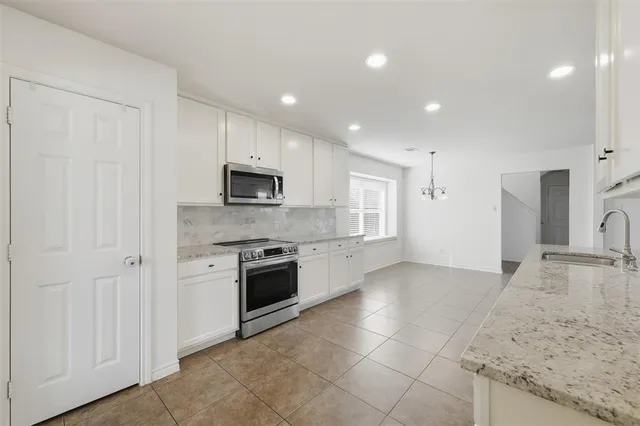 a large kitchen with a stove and a sink