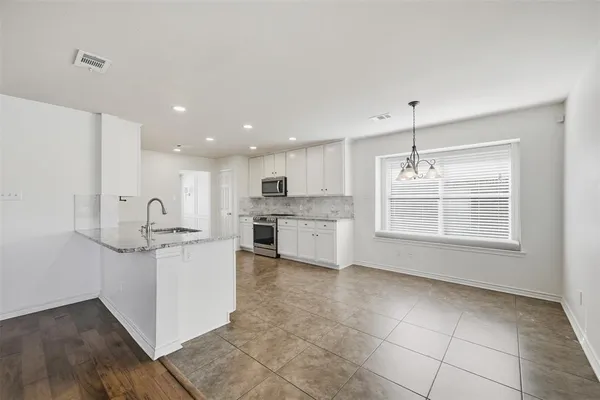 a kitchen with stainless steel appliances granite countertop a stove a sink and a refrigerator