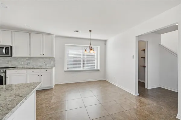 a kitchen with a sink a stove cabinets and a window