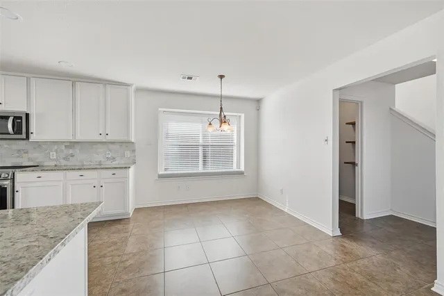a kitchen with a sink a stove cabinets and a window
