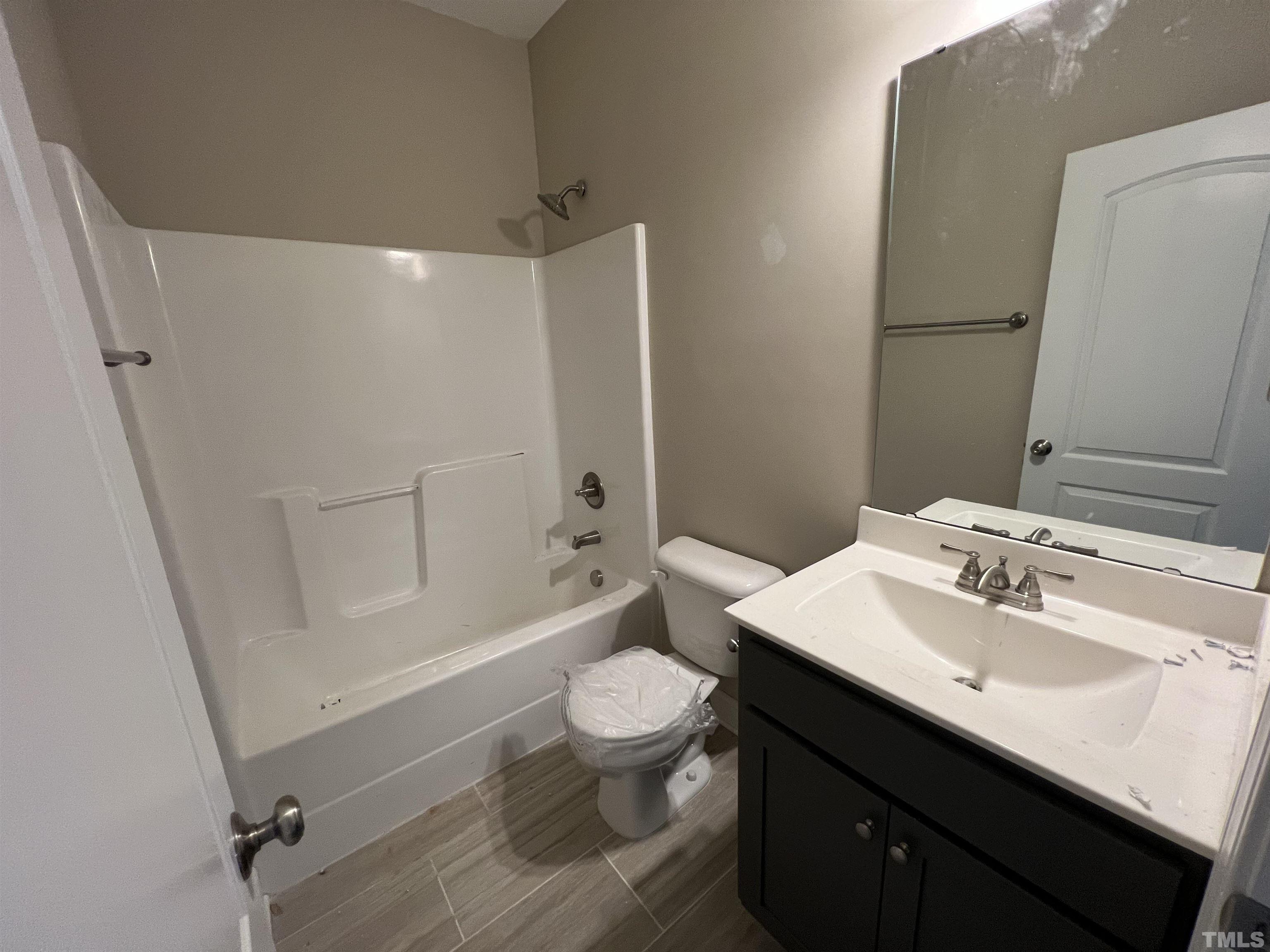 59 Cricket Hill Way Benson, NC 27504 - Photo 20 of 28 a bathroom with a sink a toilet a mirror and shower