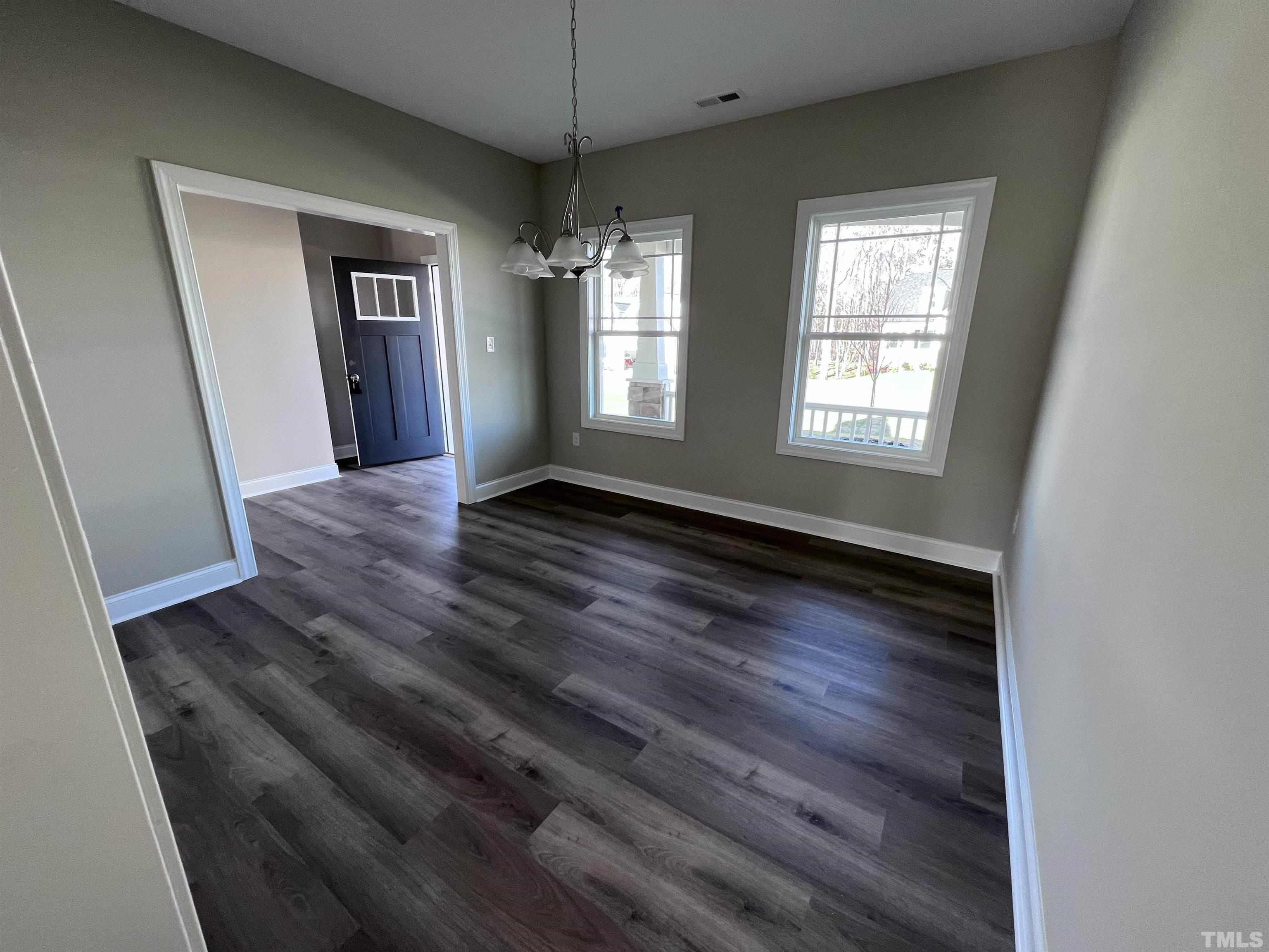 59 Cricket Hill Way Benson, NC 27504 - Photo 6 of 28 an empty room with wooden floor and windows