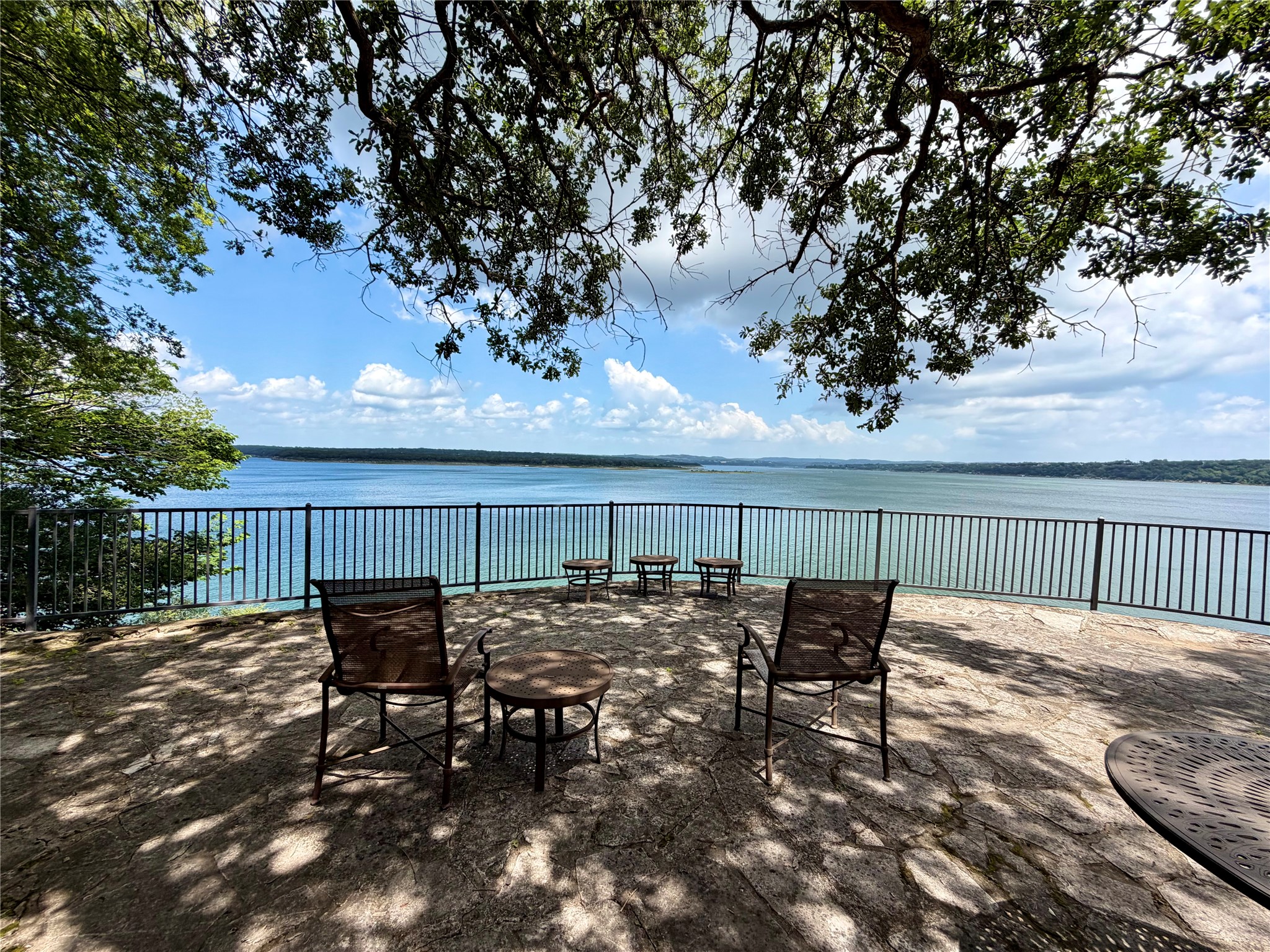 2918 Ranch Road 620 North, Unit C120 Austin, TX 78734 - Photo 29 of 34 Perched above the lake, a stone terrace offers panoramic water views, shaded by mature trees.