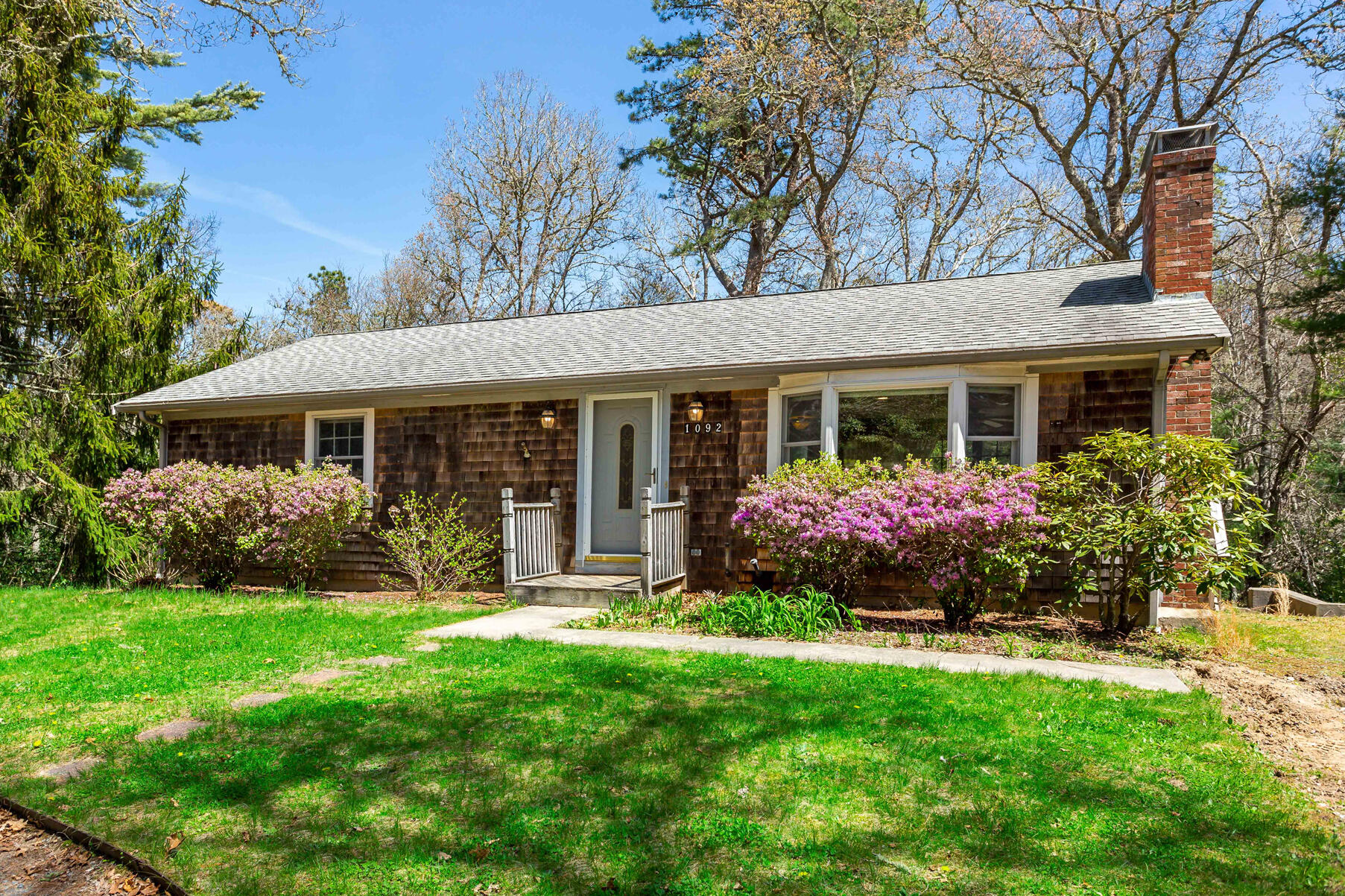 a front view of a house with garden and porch