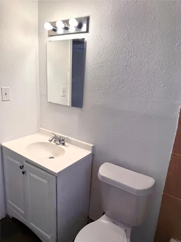 a bathroom with a toilet a sink and mirror