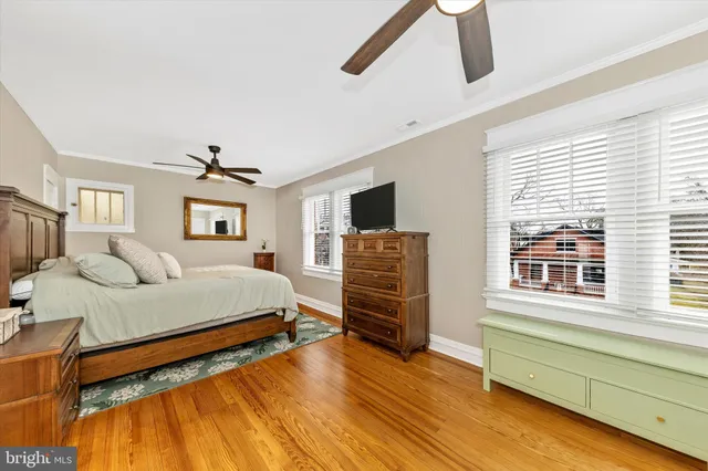 a spacious bedroom with a bed a dresser and a large window