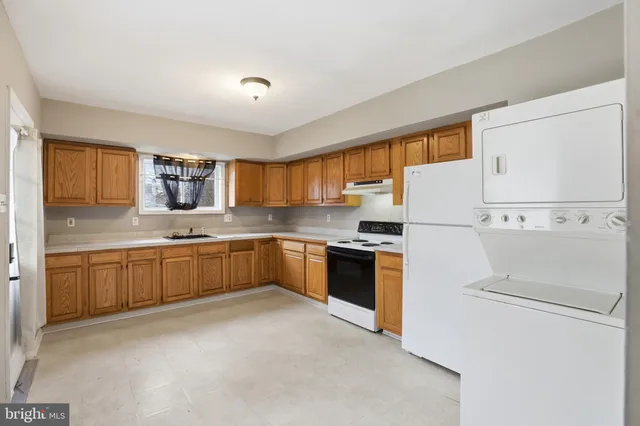 a kitchen with refrigerator a sink and white cabinets