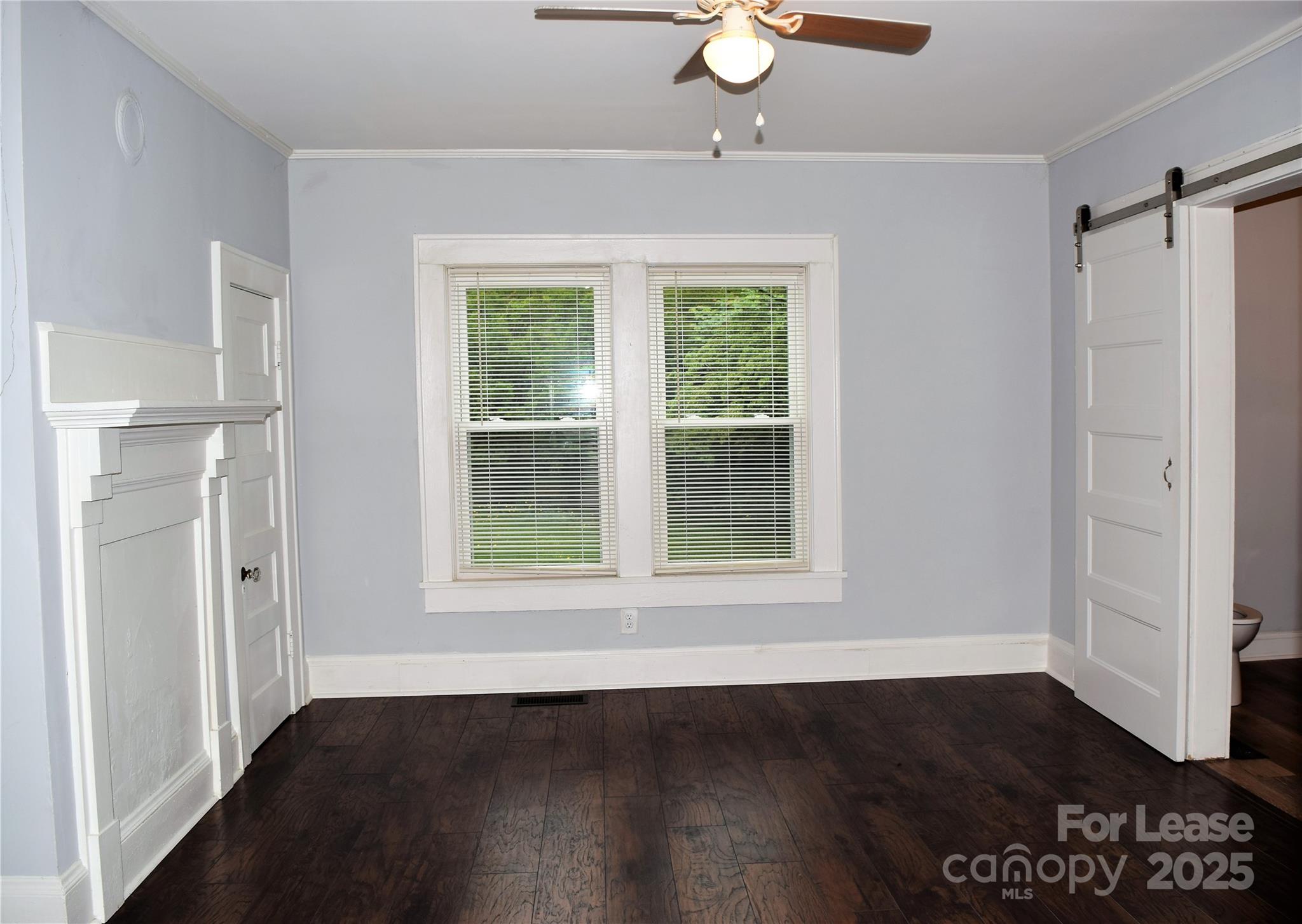 234 North Eastway Drive Troutman, NC 28166 - Photo 15 of 37 an empty room with wooden floor fan and windows