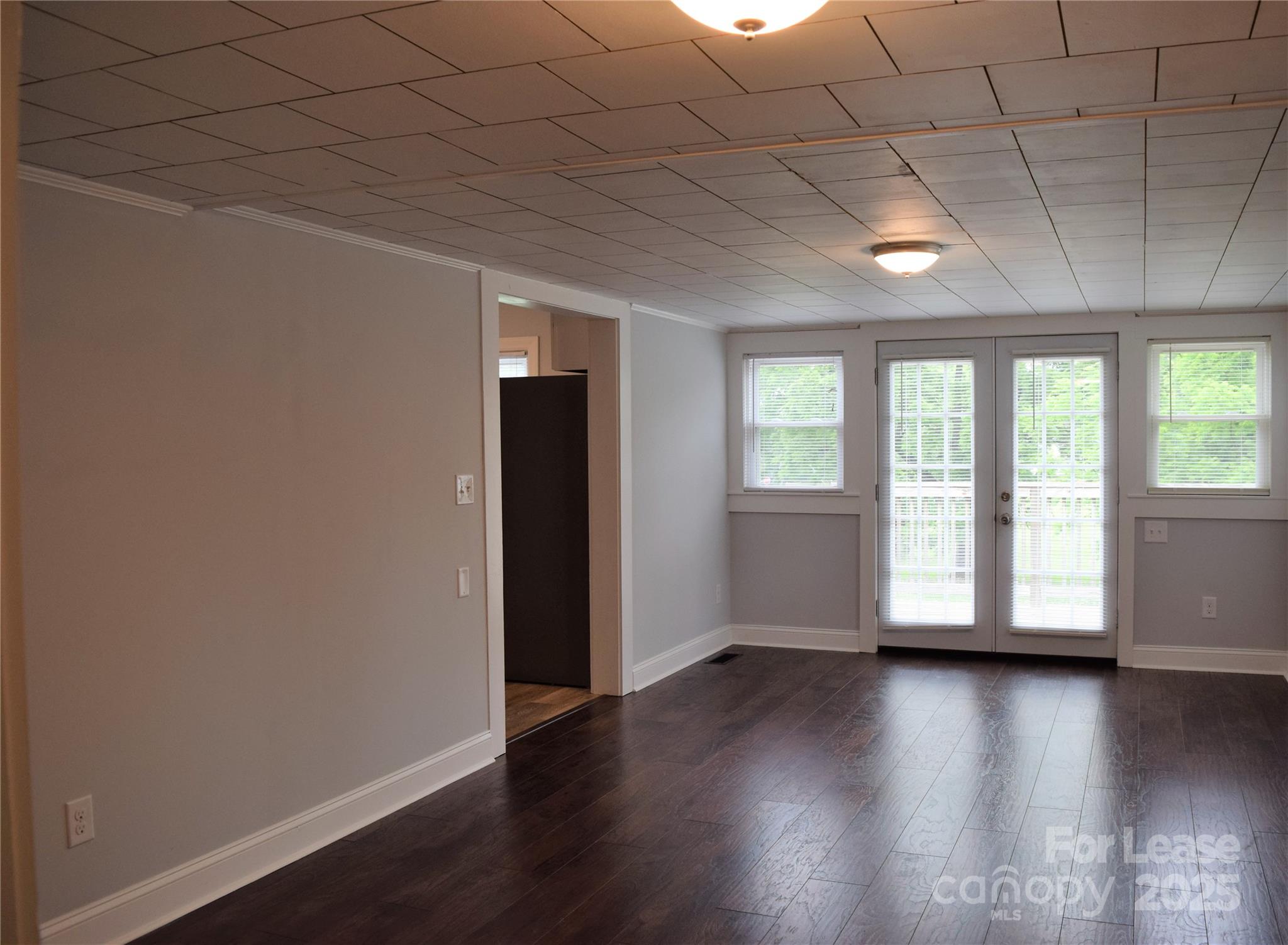 234 North Eastway Drive Troutman, NC 28166 - Photo 23 of 37 an empty room with wooden floor and windows with curtains