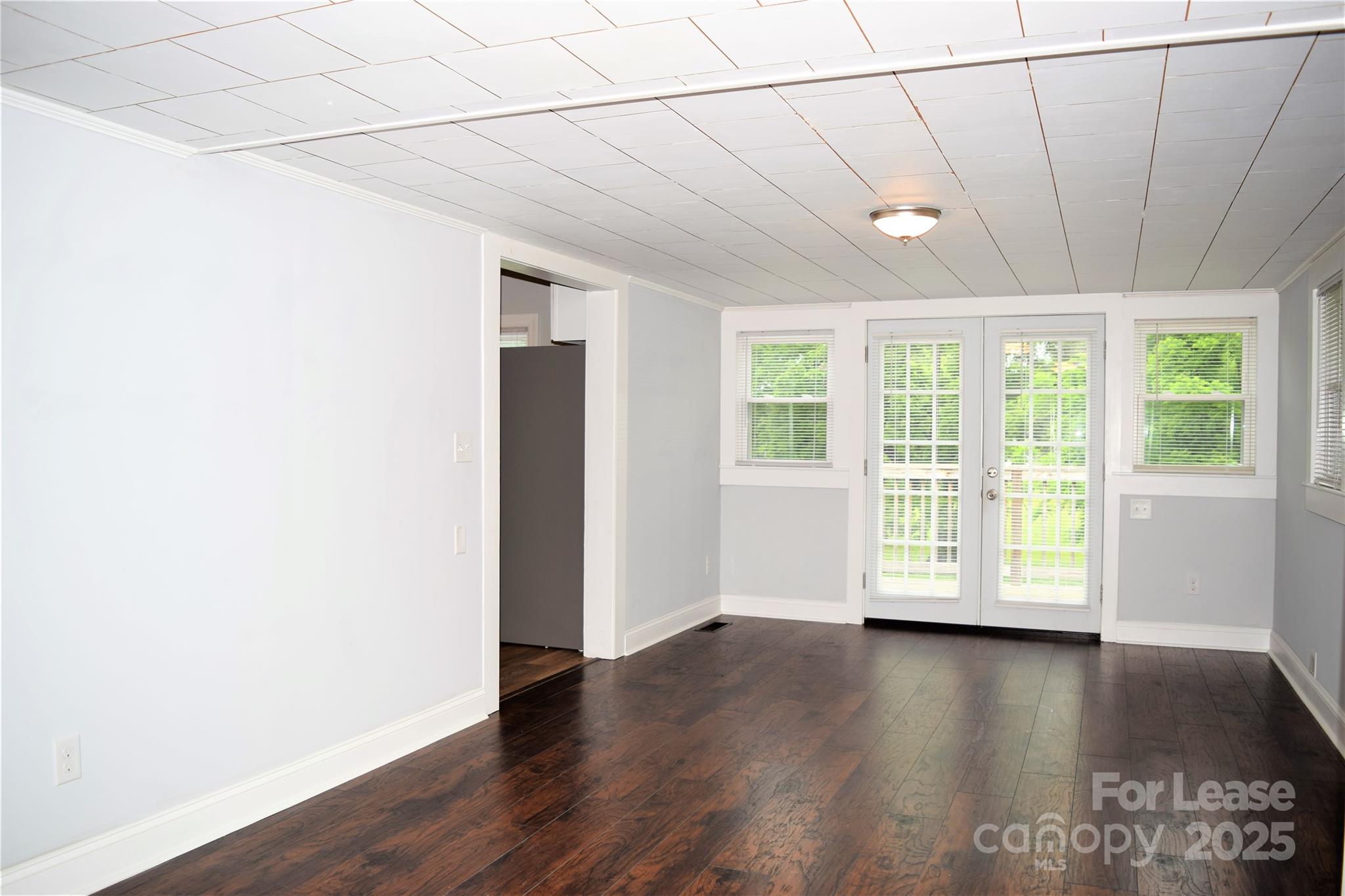 234 North Eastway Drive Troutman, NC 28166 - Photo 24 of 37 an empty room with wooden floor and windows with curtains view