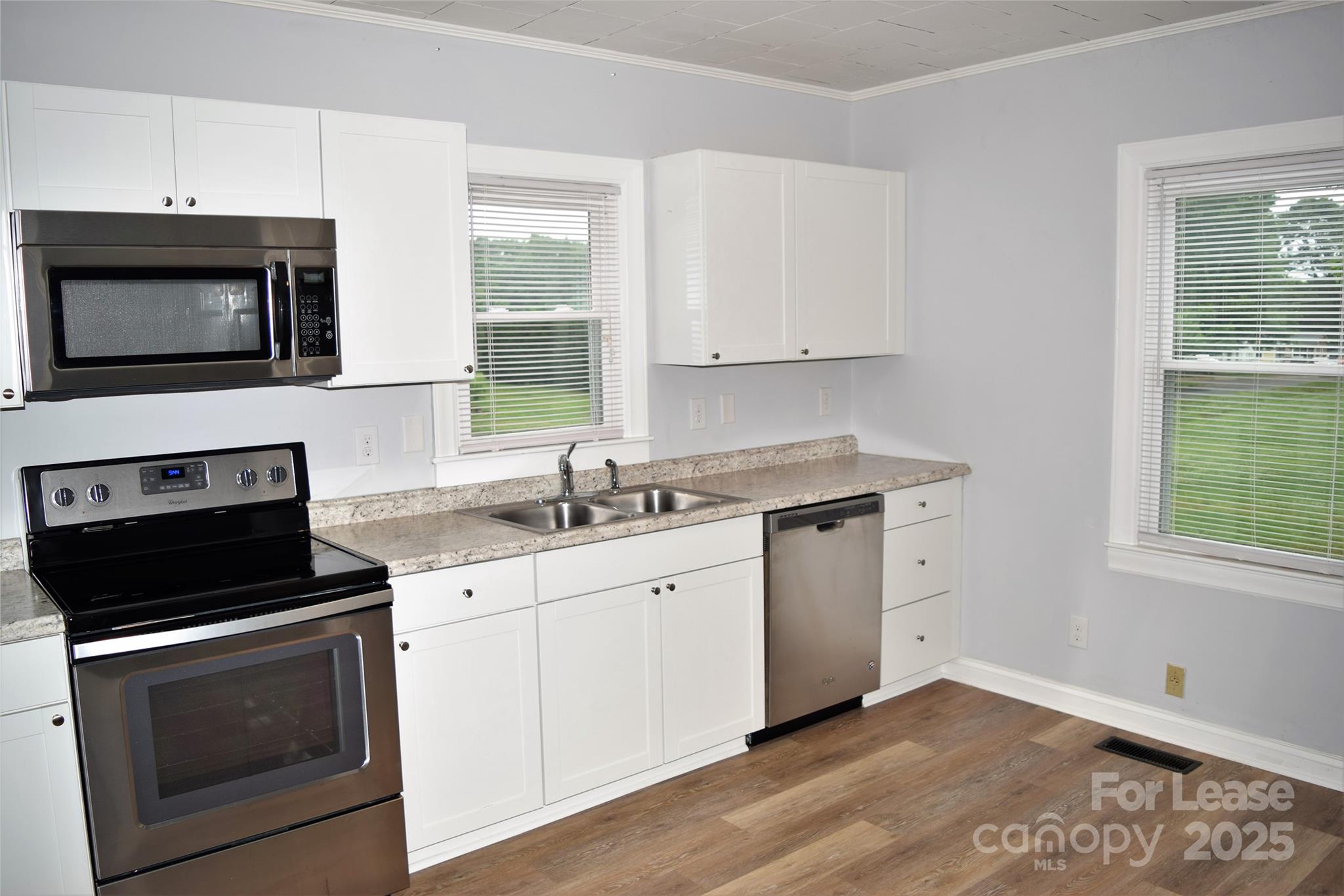 234 North Eastway Drive Troutman, NC 28166 - Photo 29 of 37 a kitchen with granite countertop white cabinets appliances a sink and a window