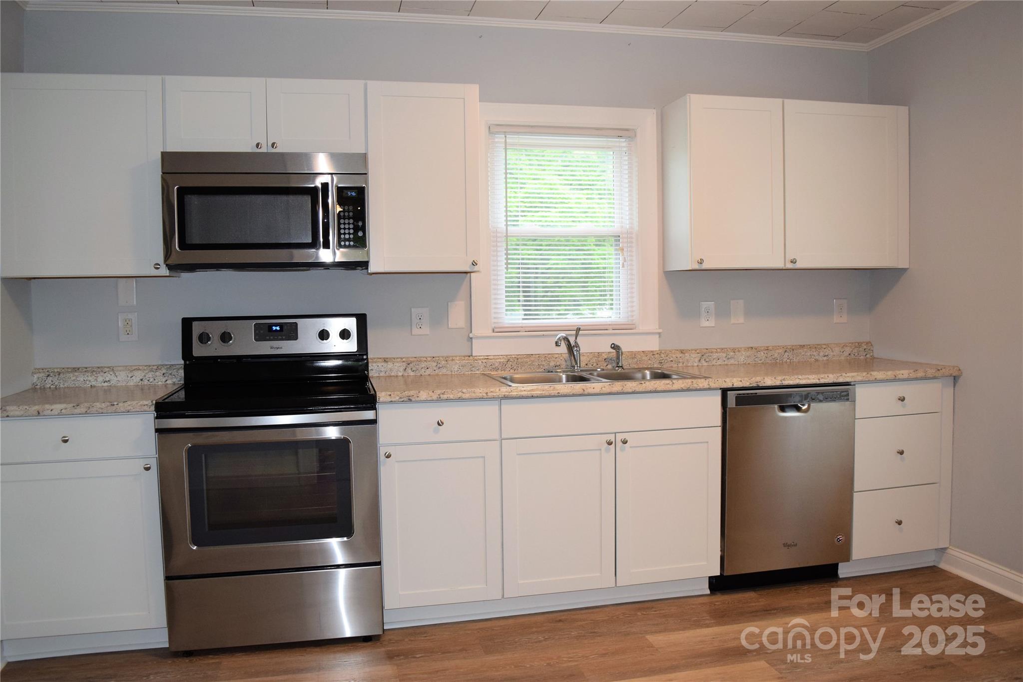 234 North Eastway Drive Troutman, NC 28166 - Photo 33 of 37 a kitchen with granite countertop white cabinets stainless steel appliances and a window