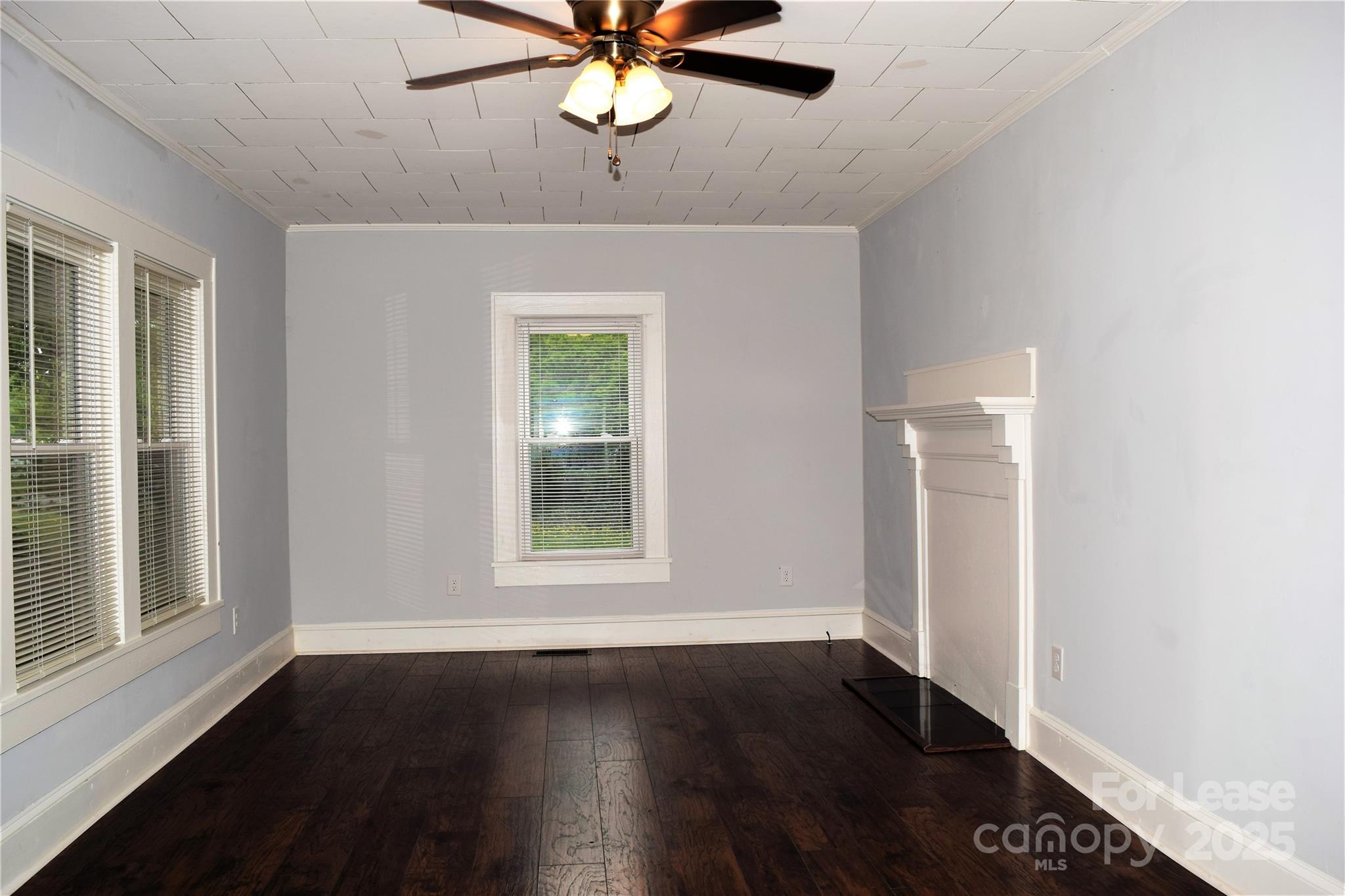 234 North Eastway Drive Troutman, NC 28166 - Photo 7 of 37 an empty room with wooden floor chandelier fan and windows